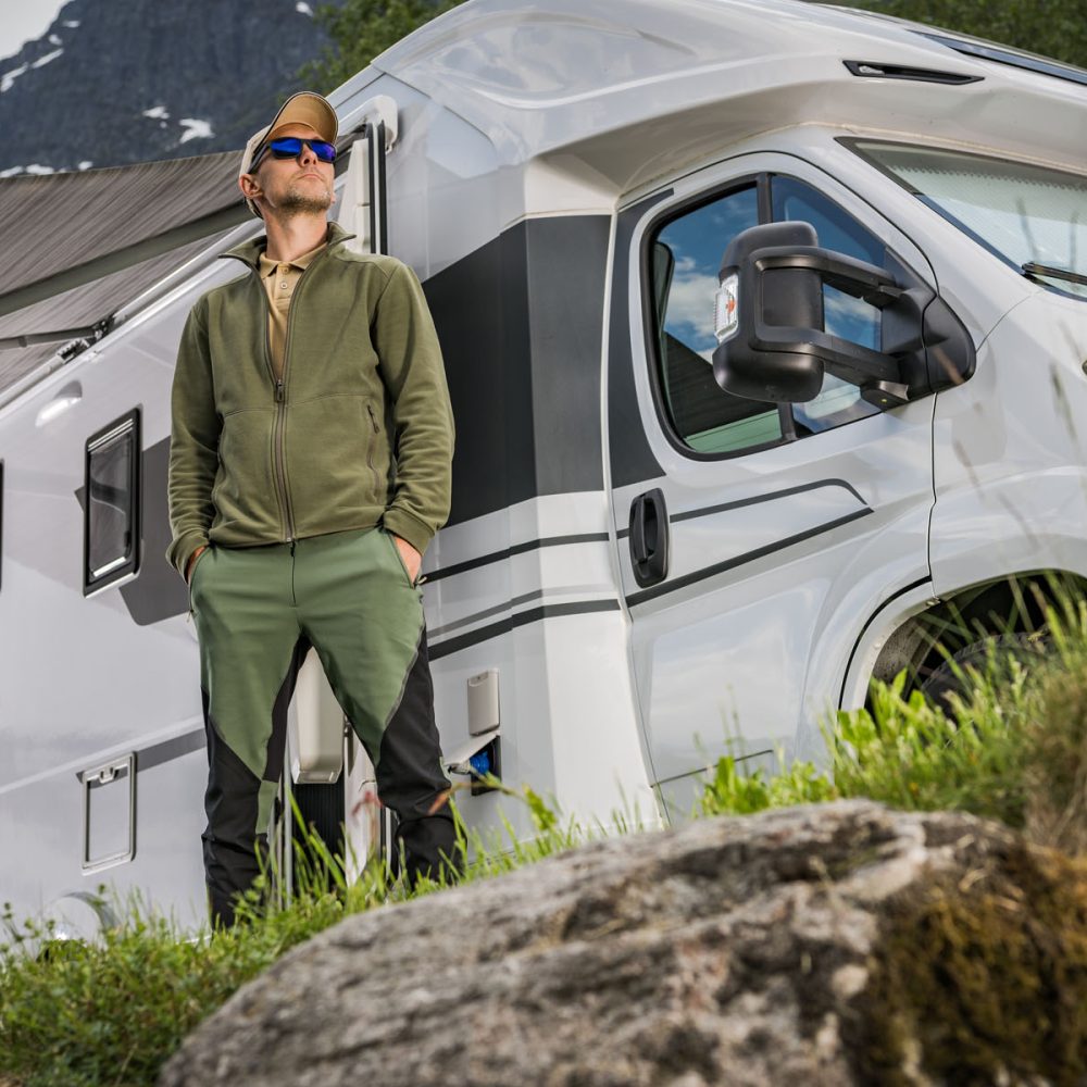 Proud Recreational Vehicle Camper Van Owner in Front of His Vehicle. Modern Camping Theme.